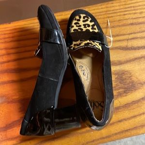 Black leather shoes with cow hide detail on top of shoes